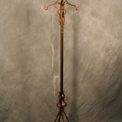 An ornate Antique Wrought Iron American Craftsman Hat & Coat Stand on a stand.