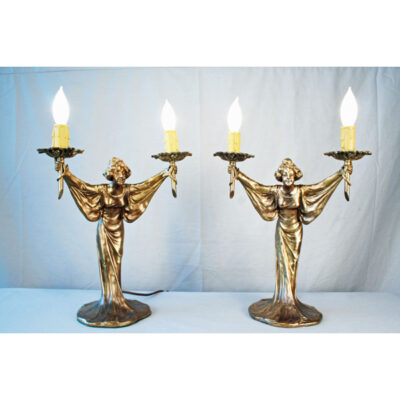 Two lamps with a candle on top of them.