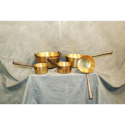 A set of brass pots and pans on top of a table.