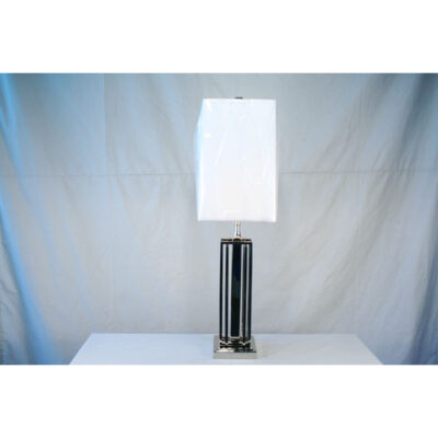 A table lamp with a white shade on top of it.